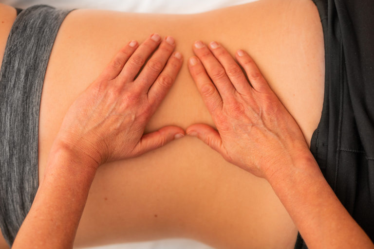 Hands on a person's back giving a massage