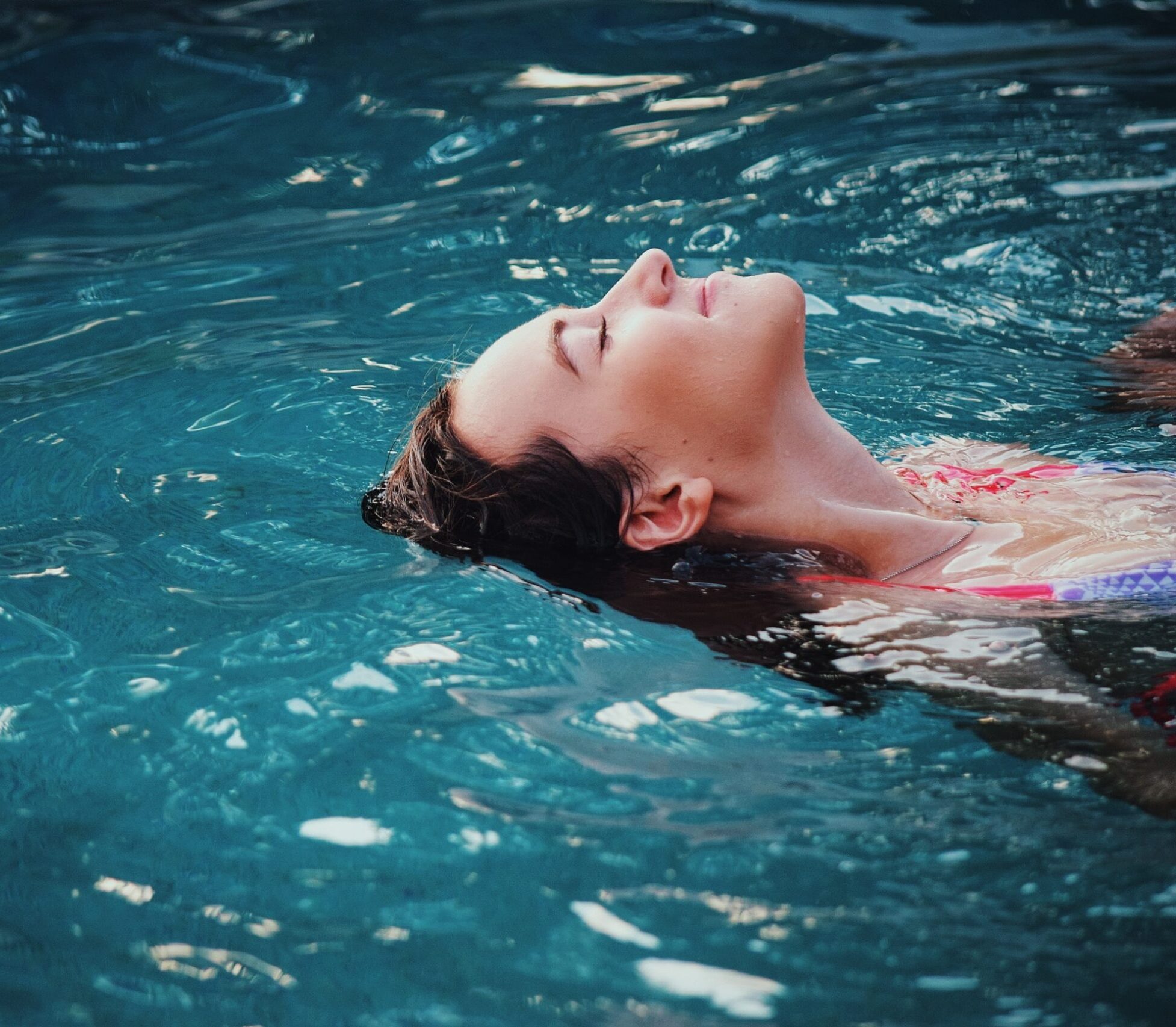 Femme flottant dans une piscine