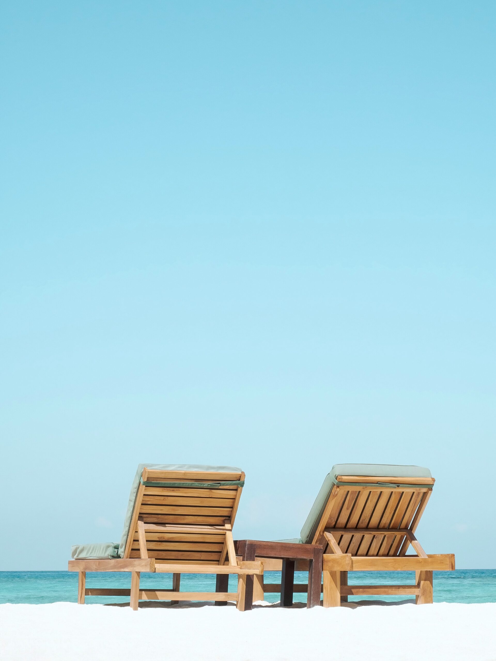 Two beach chairs next to the ocean